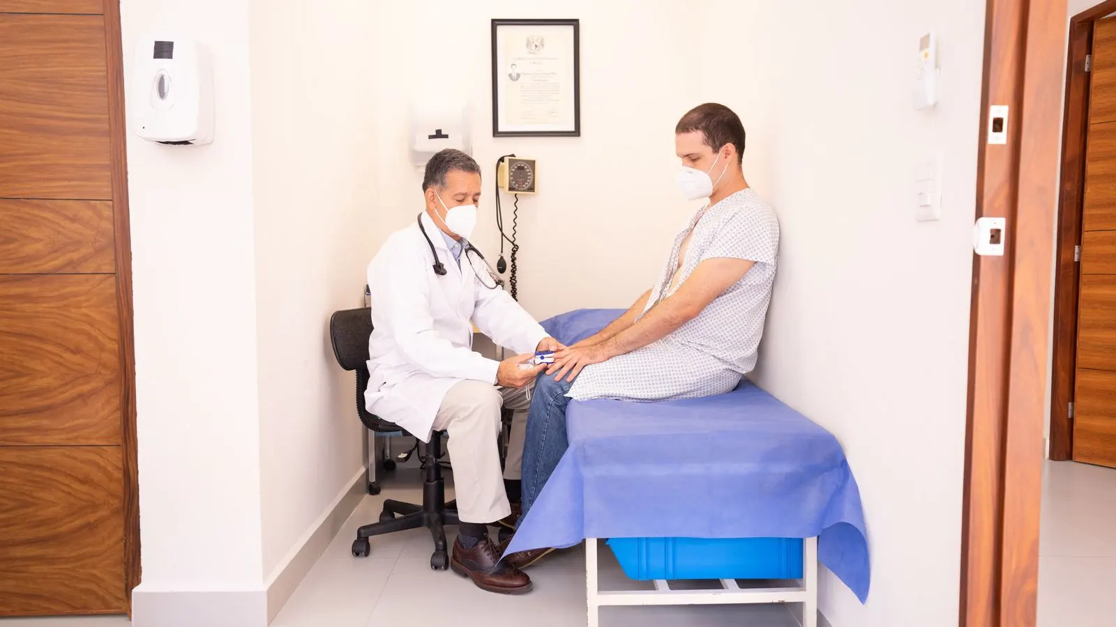A doctor reviewing a patient's vitals during a clinic consultation