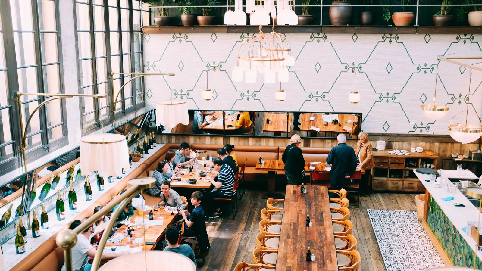 Diners seated at wooden tables in a restaurant with an open interior